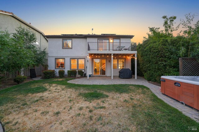 712 Tahoe Ct, Fairfield, CA 94534 - back of property at dusk featuring a balcony, a patio, a hot tub, and stucco siding