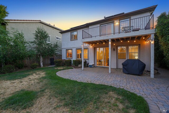 712 Tahoe Ct, Fairfield, CA 94534 - back of house at dusk featuring a balcony, a patio area, and stucco siding