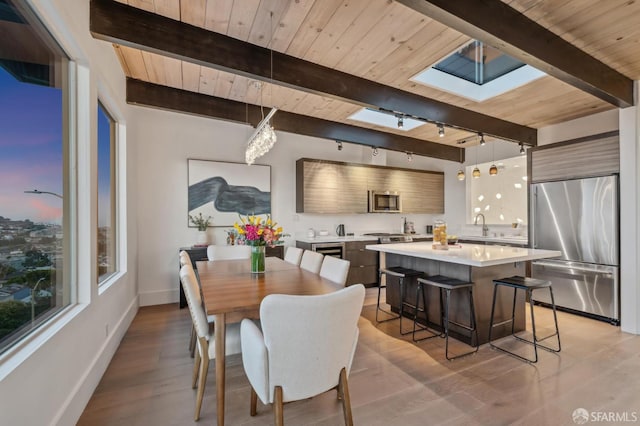 56 Aztec St, San Francisco, CA 94110 - dining area featuring wooden ceiling with exposed beams, a skylight, baseboards, light wood-style floors, and track lighting