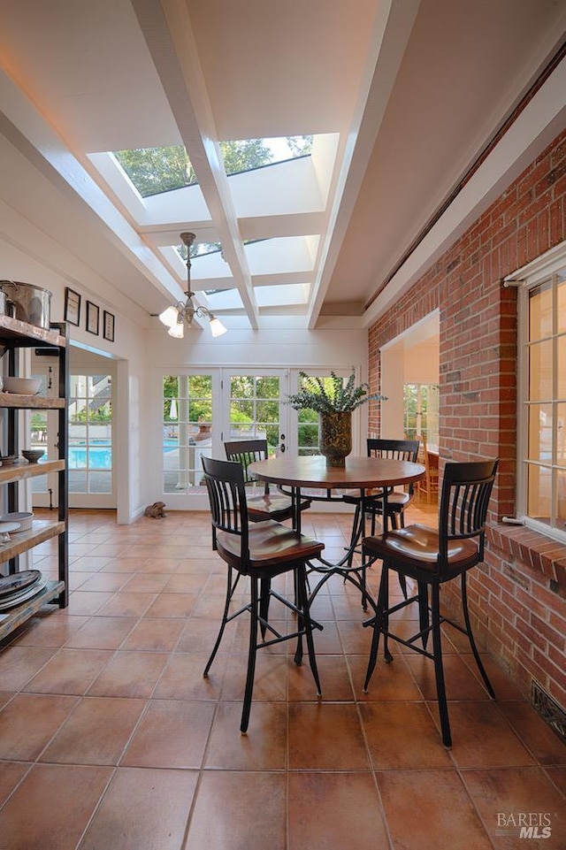 3850 Montecito Ave, Santa Rosa, CA 95404 - tiled dining space featuring a skylight, a chandelier, brick wall, and beam ceiling
