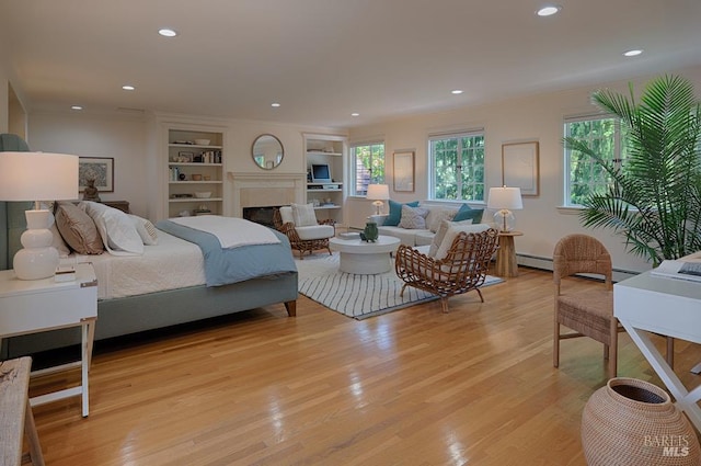 3850 Montecito Ave, Santa Rosa, CA 95404 - bedroom featuring light wood-style floors, a glass covered fireplace, recessed lighting, and a baseboard radiator