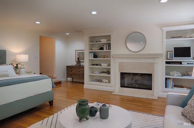 3850 Montecito Ave, Santa Rosa, CA 95404 - bedroom featuring light wood finished floors, recessed lighting, a tiled fireplace, crown molding, and baseboards