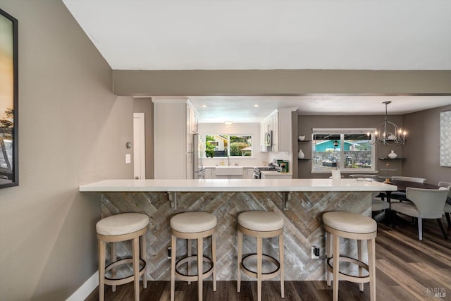 4260 Plass Dr, Napa, CA 94558 - kitchen with dark wood finished floors, stainless steel gas range oven, white cabinets, a kitchen bar, and a sink