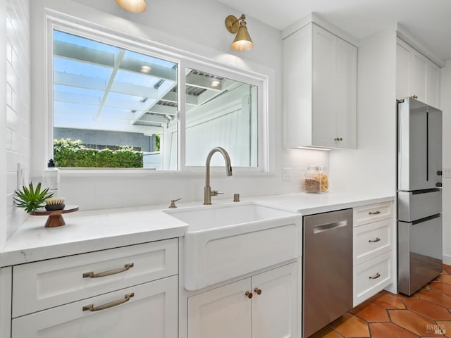 9 Park St, San Rafael, CA 94901 - kitchen with stainless steel appliances, a sink, light tile patterned floors, white cabinets, and light countertops