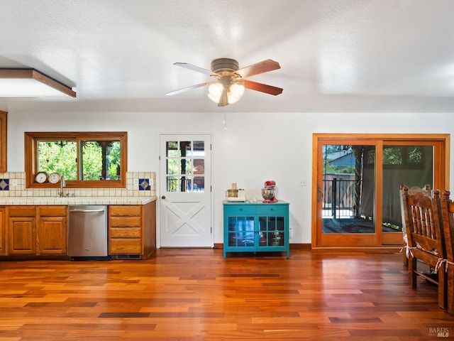 1010 Easum Dr, Napa, CA 94558 - kitchen featuring stainless steel dishwasher, wood finished floors, brown cabinetry, ceiling fan, and healthy amount of natural light