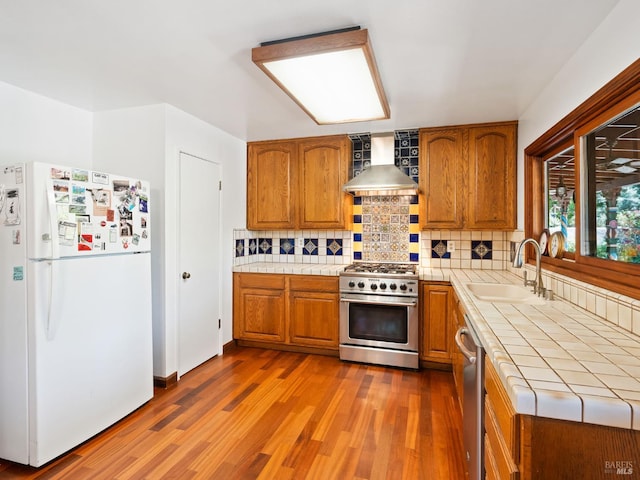 1010 Easum Dr, Napa, CA 94558 - kitchen with appliances with stainless steel finishes, wall chimney range hood, tile countertops, a sink, and brown cabinets