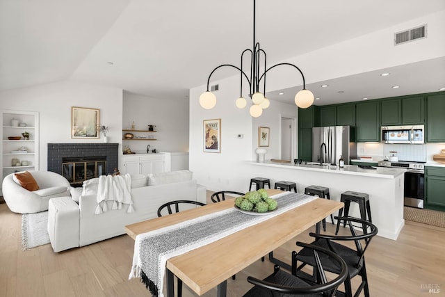 34 Laurel Dr, Corte Madera, CA 94925 - dining area featuring light wood-style flooring, vaulted ceiling, and a fireplace