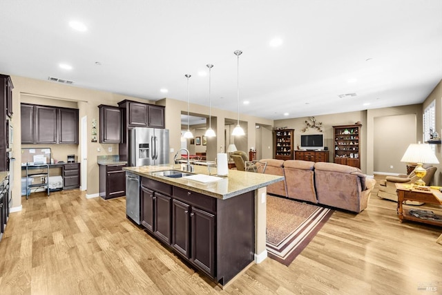 2234 Pullen Ln, Fairfield, CA 94533 - kitchen featuring stainless steel appliances, a sink, open floor plan, dark brown cabinetry, and light wood-style flooring