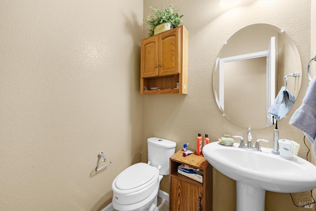 2234 Pullen Ln, Fairfield, CA 94533 - half bathroom featuring toilet, baseboards, and a sink