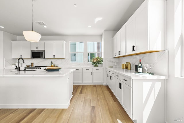 1480 Waterside Ln, Rohnert Park, CA 94928 - kitchen featuring a sink, decorative backsplash, white cabinets, light wood-style floors, and decorative light fixtures