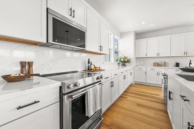 1480 Waterside Ln, Rohnert Park, CA 94928 - kitchen with stainless steel appliances, white cabinets, light stone countertops, tasteful backsplash, and recessed lighting