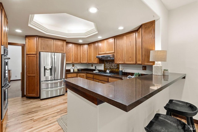 192 Carson Rd, Woodacre, CA 94973 - kitchen with stainless steel appliances, under cabinet range hood, a peninsula, a breakfast bar area, and recessed lighting