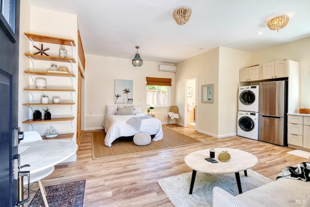 3051 Edison St, Graton, CA 95444 - bedroom featuring freestanding refrigerator, a wall mounted air conditioner, stacked washer / drying machine, light wood-style flooring, and baseboards