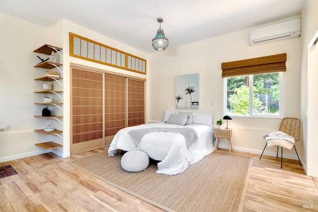 3051 Edison St, Graton, CA 95444 - bedroom featuring an AC wall unit, wood finished floors, and baseboards