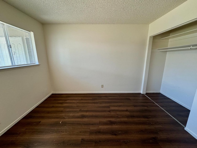 5972 Walerga Rd Unit 1, Sacramento, CA 95842 - unfurnished bedroom featuring dark wood-type flooring, a textured ceiling, a closet, and baseboards