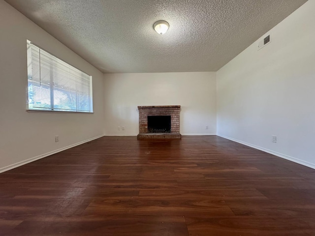 5972 Walerga Rd Unit 1, Sacramento, CA 95842 - unfurnished living room with a textured ceiling, dark wood finished floors, a brick fireplace, and baseboards