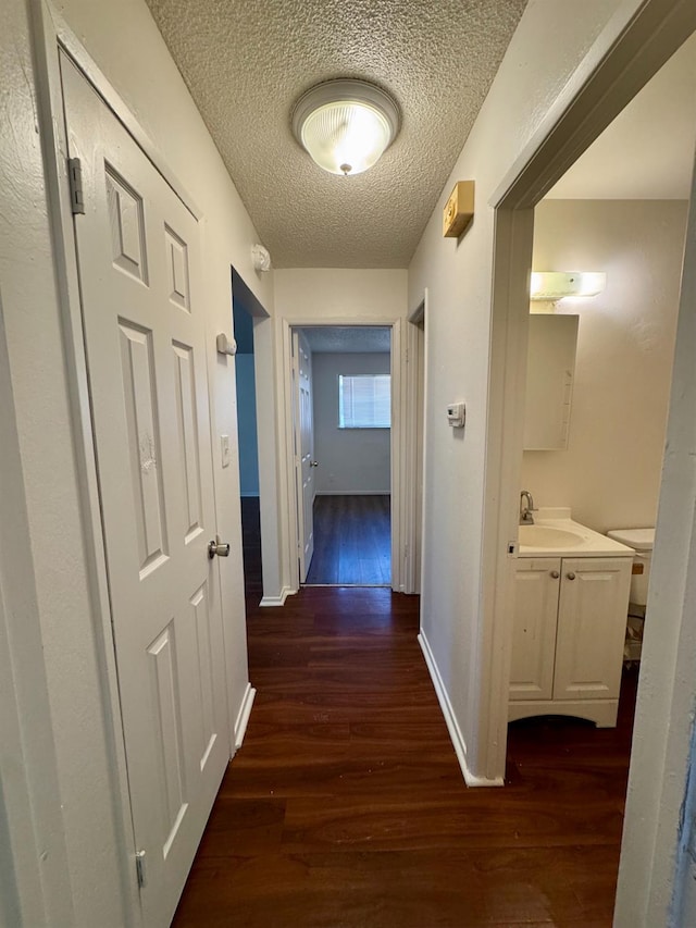 5972 Walerga Rd Unit 1, Sacramento, CA 95842 - corridor with dark wood-style floors, a sink, a textured ceiling, and baseboards