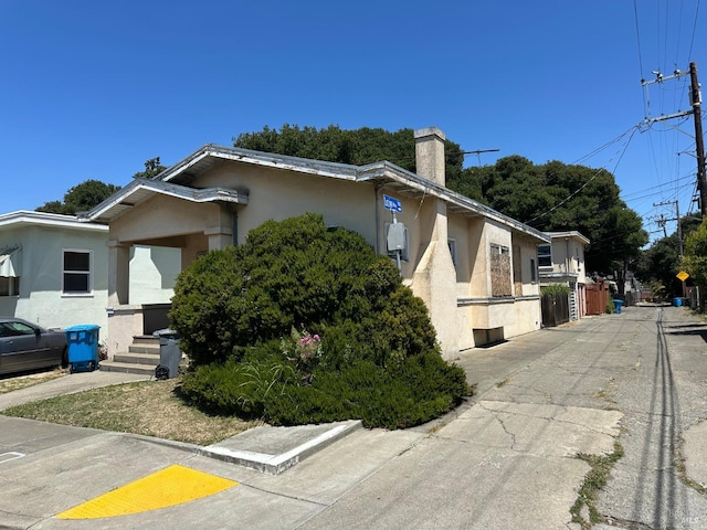 718 Monterey St, Vallejo, CA 94590 - view of side of home with stucco siding and a chimney