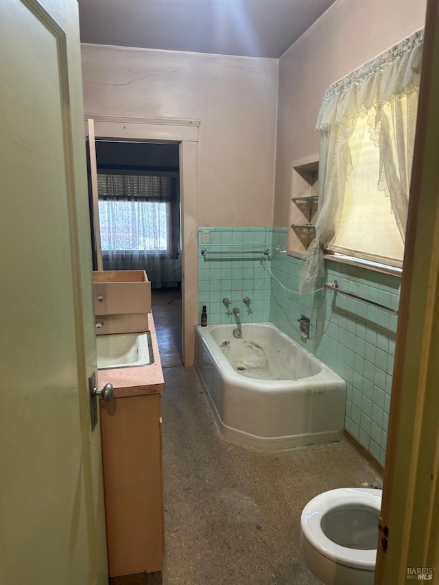 718 Monterey St, Vallejo, CA 94590 - full bathroom with tile walls, toilet, vanity, a bath, and wainscoting