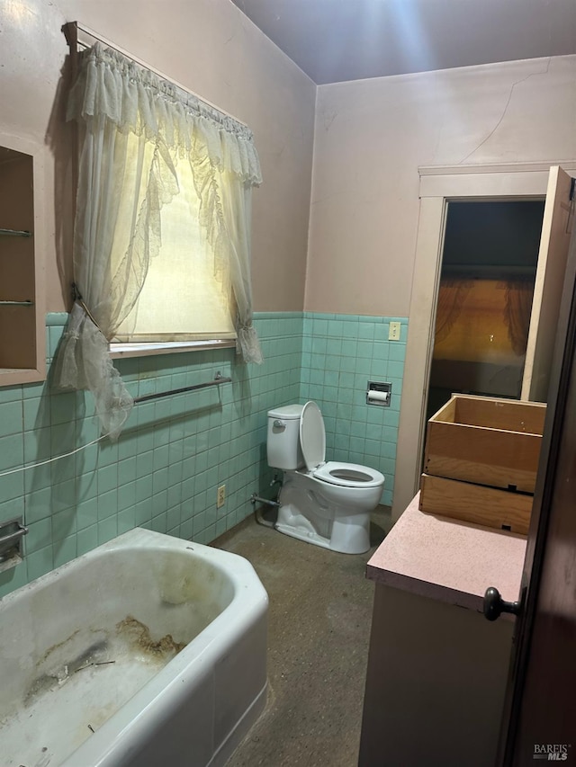 718 Monterey St, Vallejo, CA 94590 - bathroom featuring toilet, vanity, wainscoting, tile walls, and a tub