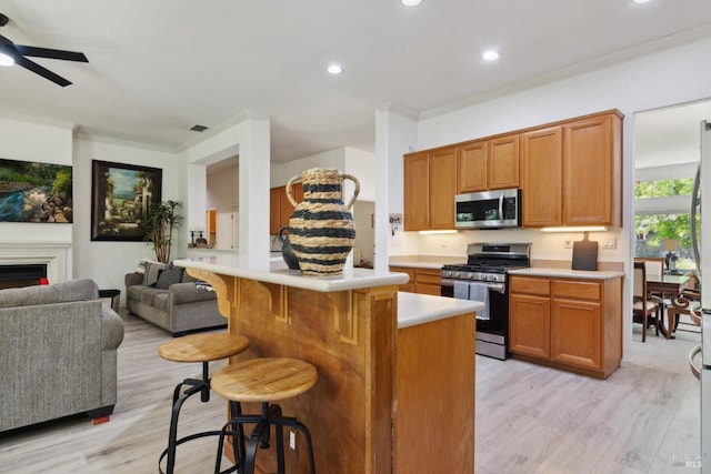 602 Summerset Dr, Rio Vista, CA 94571 - kitchen featuring appliances with stainless steel finishes, crown molding, light countertops, open floor plan, and a kitchen bar