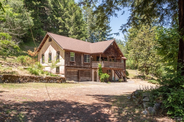 10520 Hwy 116, Forestville, CA 95436 - view of front facade with stairs, dirt driveway, an attached garage, a wooden deck, and roof with shingles