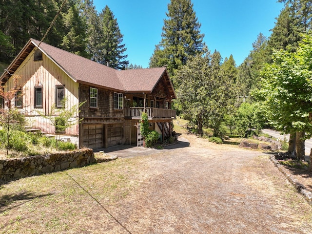 10520 Hwy 116, Forestville, CA 95436 - view of front of home featuring dirt driveway, an attached garage, stairs, roof with shingles, and board and batten siding