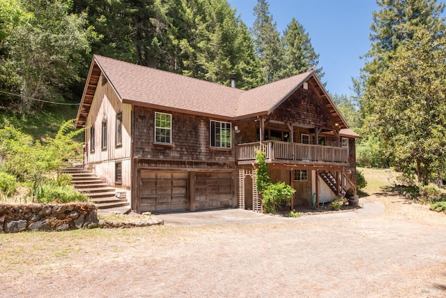 10520 Hwy 116, Forestville, CA 95436 - view of front of house featuring stairway, driveway, a garage, a shingled roof, and a wooden deck