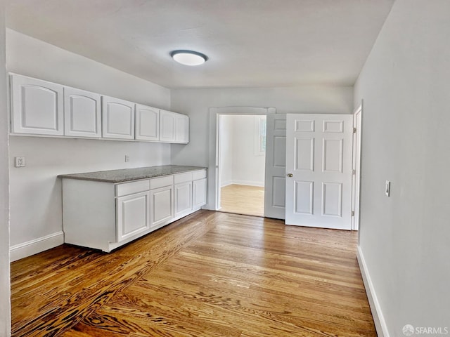 108 Naglee Ave, San Francisco, CA 94112 - kitchen featuring white cabinetry, light wood-type flooring, baseboards, and light stone countertops