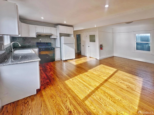 108 Naglee Ave, San Francisco, CA 94112 - kitchen with black gas range, freestanding refrigerator, a sink, light wood-style flooring, and under cabinet range hood