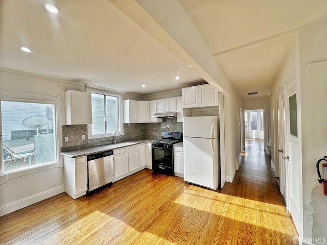 108 Naglee Ave, San Francisco, CA 94112 - kitchen featuring freestanding refrigerator, stainless steel dishwasher, black gas range, under cabinet range hood, and backsplash