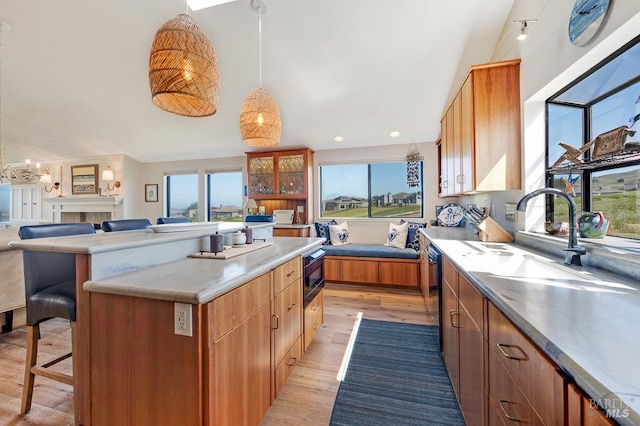 21199 Hummingbird Ct, Bodega Bay, CA 94923 - kitchen featuring a sink, light wood-style floors, a breakfast bar area, a center island, and glass insert cabinets