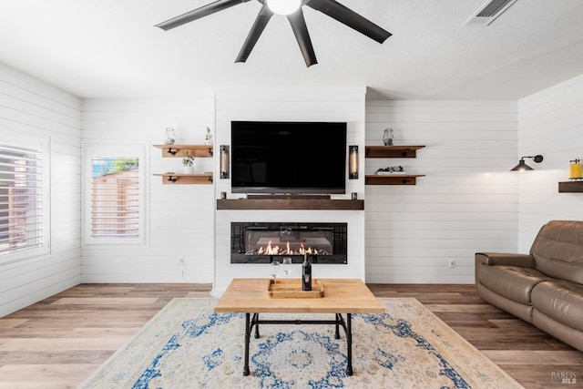 420 Georgetown Pl, Dixon, CA 95620 - living area featuring ceiling fan, wood finished floors, a large fireplace, and wooden walls