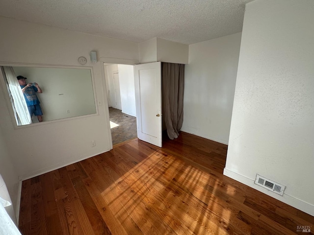 942 Benicia Rd, Vallejo, CA 94591 - empty room with wood finished floors, a textured ceiling, and baseboards