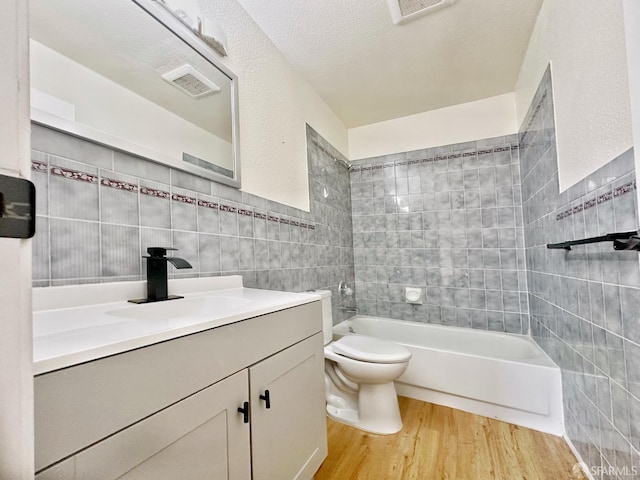 1927 Taraval St, San Francisco, CA 94116 - bathroom with tile walls, wood finished floors, vanity, toilet, and tub / shower combination
