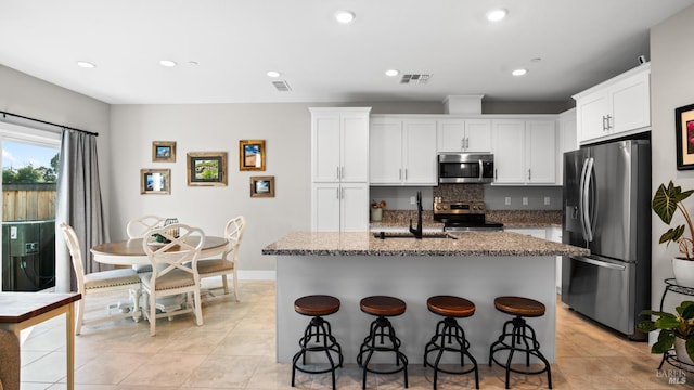1212 Del Rancho Way, Petaluma, CA 94954 - kitchen with stainless steel appliances, a sink, stone counters, a kitchen breakfast bar, and a center island with sink