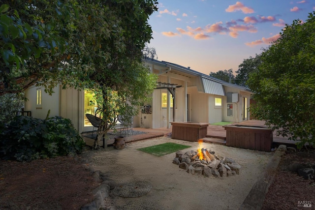 10 Waldruhe Hts, Glen Ellen, CA 95442 - back of house at dusk with a fire pit, a hot tub, and a patio area
