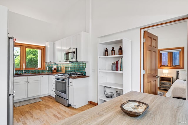 10 Waldruhe Hts, Glen Ellen, CA 95442 - kitchen with appliances with stainless steel finishes, white cabinets, light wood-style flooring, and decorative backsplash