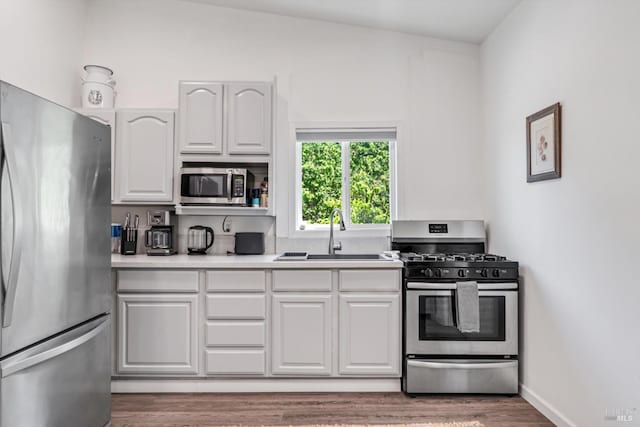 10 Waldruhe Hts, Glen Ellen, CA 95442 - kitchen with appliances with stainless steel finishes, a sink, light wood-style floors, light countertops, and white cabinets