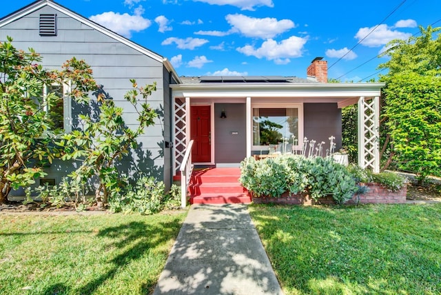 1645 Georgia St, Napa, CA 94559 - view of front of home featuring covered porch, a front lawn, roof mounted solar panels, and a chimney