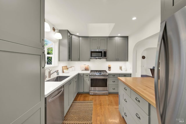 1645 Georgia St, Napa, CA 94559 - kitchen with stainless steel appliances, a sink, gray cabinetry, arched walkways, and backsplash
