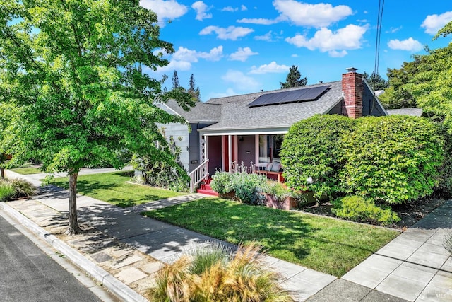 1645 Georgia St, Napa, CA 94559 - view of front facade featuring a porch, roof with shingles, roof mounted solar panels, a front lawn, and a chimney