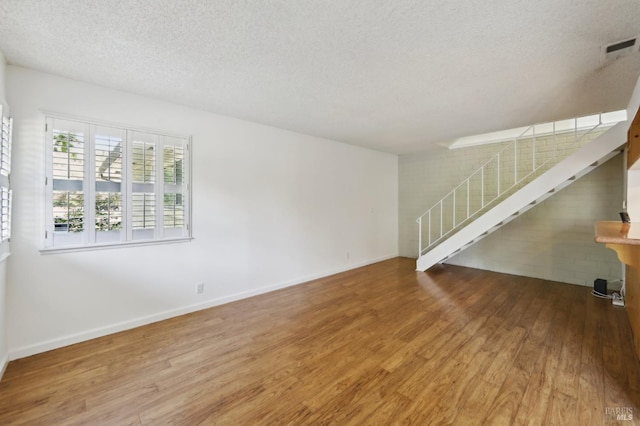 38 Plumas Cir, Novato, CA 94947 - unfurnished living room with wood finished floors, a textured ceiling, stairs, and baseboards