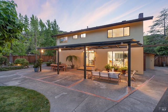 522 Blackstone Dr, San Rafael, CA 94903 - back of house at dusk featuring a patio area, stucco siding, outdoor dining area, and a chimney