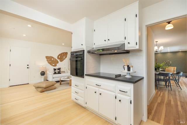 522 Blackstone Dr, San Rafael, CA 94903 - kitchen featuring black appliances, under cabinet range hood, dark countertops, light wood-style flooring, and white cabinets