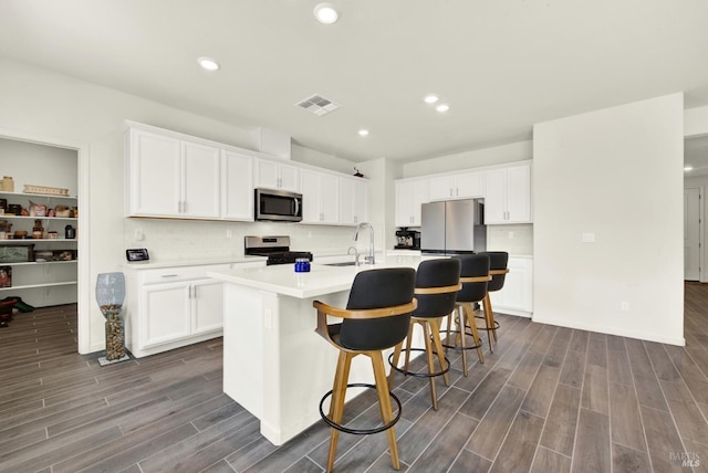 544 Oakham Dr, Vacaville, CA 95687 - kitchen with stainless steel appliances, dark wood-style floors, an island with sink, white cabinets, and recessed lighting