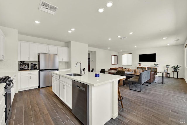 544 Oakham Dr, Vacaville, CA 95687 - kitchen with appliances with stainless steel finishes, a sink, dark wood-style flooring, an island with sink, and recessed lighting