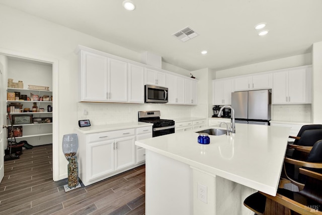 544 Oakham Dr, Vacaville, CA 95687 - kitchen featuring appliances with stainless steel finishes, a sink, a kitchen breakfast bar, white cabinets, and tasteful backsplash