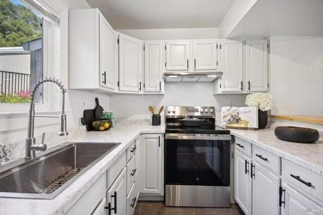 1259 Royal Oak Ter Unit A, Novato, CA 94947 - kitchen featuring electric range, a sink, under cabinet range hood, white cabinetry, and dark tile patterned flooring