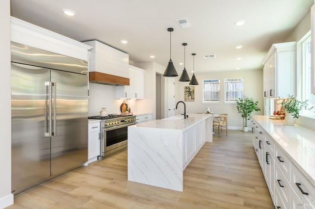 1970 Bent Tree Pl, Santa Rosa, CA 95404 - kitchen with premium appliances, custom exhaust hood, white cabinetry, a center island with sink, and recessed lighting